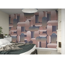 Chambre avec un mur recouvert de papier peint à motifs géométriques.