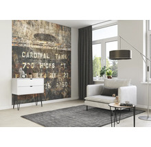 Wohnzimmer mit gemusterter Tapete, Sessel, Stehlampe und Kommode