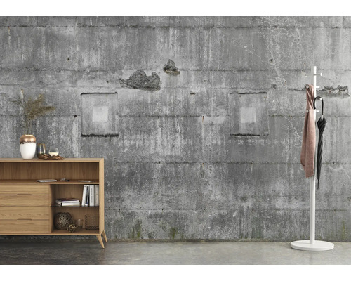 Séjour avec commode en bois et portemanteau devant un mur en béton