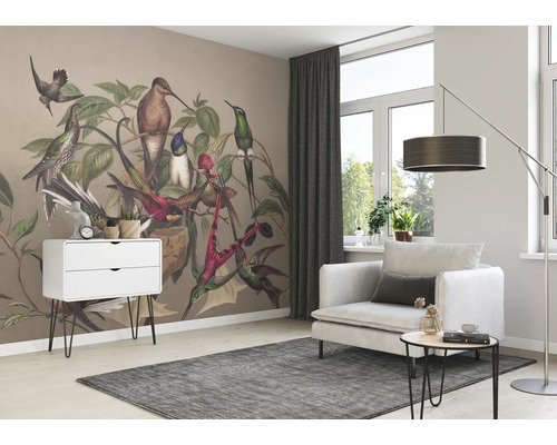 Salon avec papier peint d''oiseaux, fauteuil, tapis et commode pour une ambiance lumineuse et conviviale