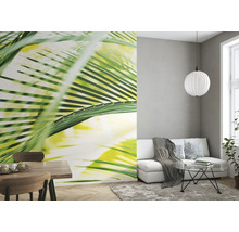 Wohnzimmer mit Fototapete mit Palmenmotiv, Sofa und Esstisch