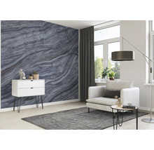 Wohnzimmer mit grauer Marmortapete, weißem Schrank, Sessel und grauem Teppich