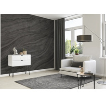 Salon avec papier peint gris imitation marbre, fauteuil, lampadaire et commode