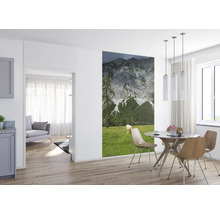 Wohnraum mit Esstischgruppe und Wandbild Berglandschaft