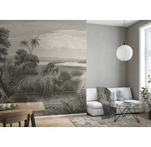 Wohnzimmer mit gemusterter Tapete mit Elefantenmotiv, Sofa, Tisch und Dekorationen.