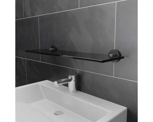 Waschbecken mit Glasablage und Armatur im Badezimmer.