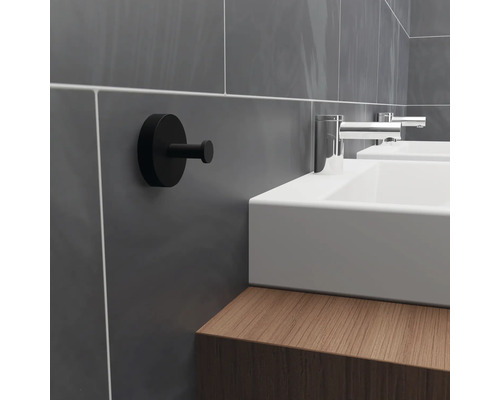 Badezimmerszene mit Waschbecken, Armaturen und schwarzem Haken