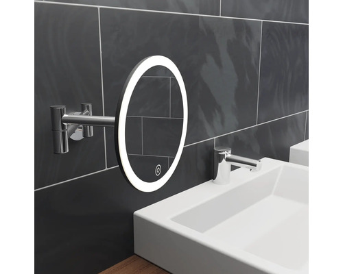 Miroir ovale lumineux avec bras sur un mur de salle de bain au-dessus d''un lavabo