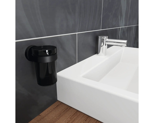 Schwarzer Zahnputzbecher zur Wandmontage neben einem Waschbecken