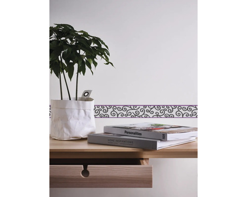 Décoration murale avec bordure, plante et livres sur une table