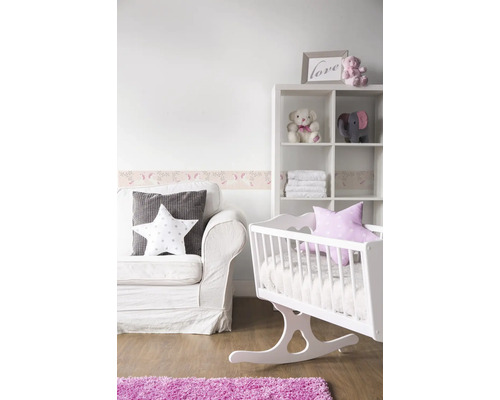 Chambre de bébé avec canapé blanc, berceau, étagère et tapis rose