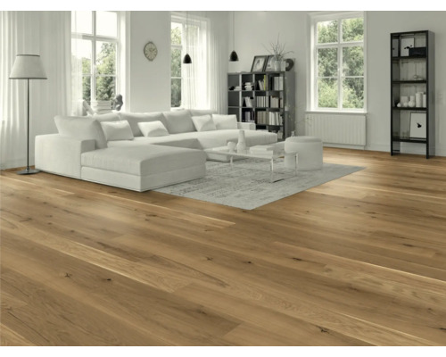 Salon avec plancher en bois, canapé et bibliothèque