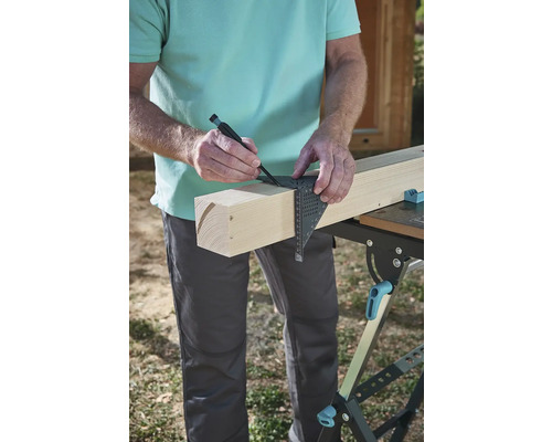 Handwerker zeichnet mit einem Winkel und Stift eine Markierung auf einem Holzbrett.