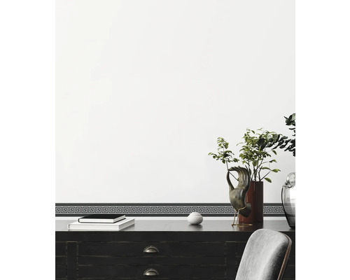 Bordure décorative avec motif de méandre grec sur un mur au-dessus d''un bureau.
