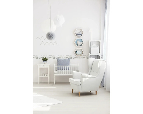 Chambre d''enfant claire avec lit de bébé, fauteuil et décoration murale