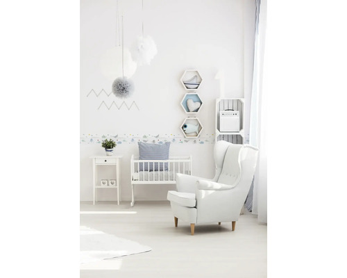 Chambre d''enfant lumineuse avec lit de bébé, fauteuil et éléments décoratifs.