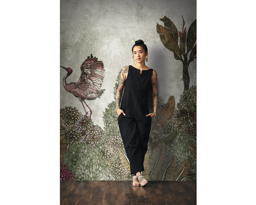 Femme devant un papier peint photo à motifs avec des motifs végétaux