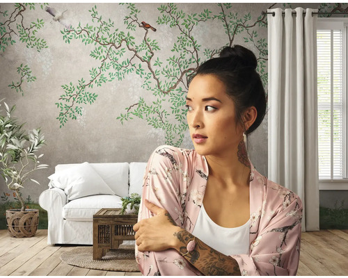 Salon avec papier peint floral, canapé et femme en peignoir