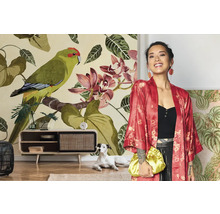 Frau mit rotem Kimono vor einer floralen Fototapete mit Papageien und Orchideen in einem hellen Wohnzimmer