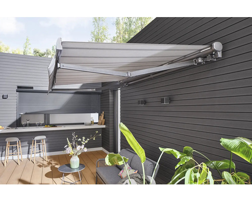 Terrasse avec store, coin salon et cuisine extérieure