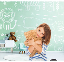 Fille étreignant un ours en peluche devant un mur avec des dessins d''animaux dans une chambre d''enfant.