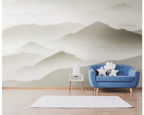 Pièce lumineuse avec papier peint montagne, canapé bleu et tapis blanc