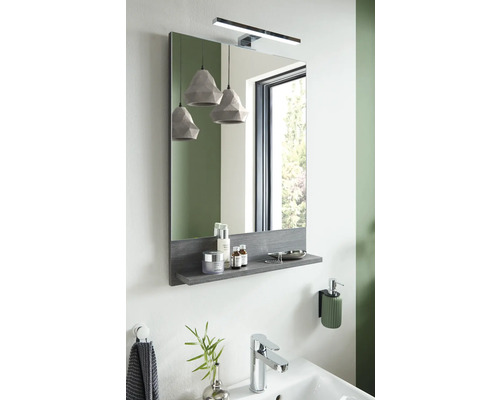 Badezimmerszene mit Spiegel, Ablage, Lampe und Waschbecken