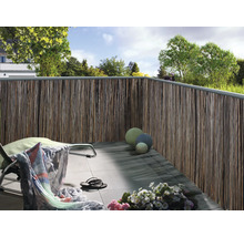 Balcon avec brise-vue en matériaux naturels, chaise longue et décoration