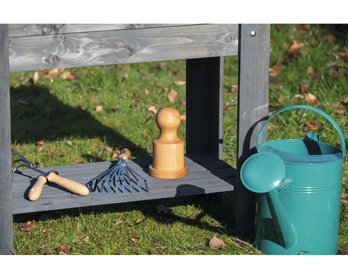 Table de jardin avec outils de jardinage et arrosoir