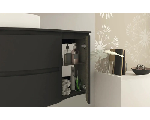 Meuble sous-lavabo avec porte ouverte, serviettes et produits de soin à l''intérieur