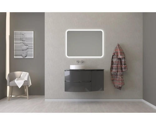 Salle de bains avec meuble sous-lavabo, lavabo, miroir lumineux et décoration pour une atmosphère claire et organisée.