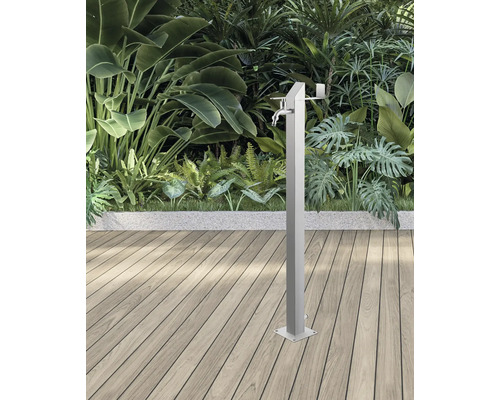 Gartendusche aus Metall mit Wasserhahn vor Pflanzen