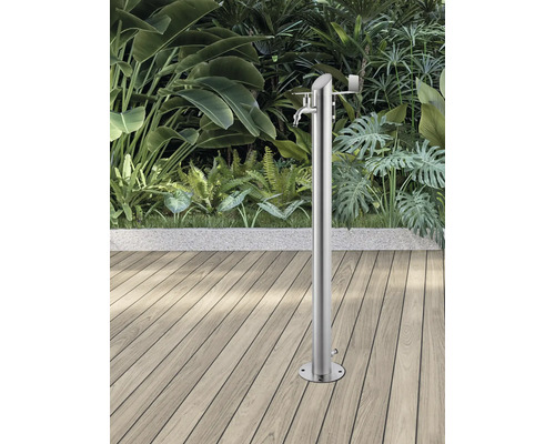 Gartendusche aus Edelstahl auf Holzterrasse vor üppigem Grün