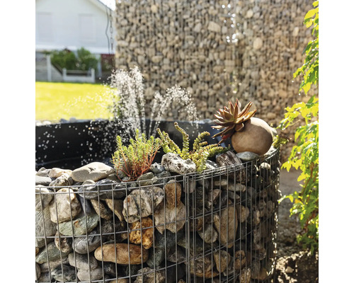 Gabionenbrunnen mit Steinen, Pflanzen und Wasserspiel im Garten