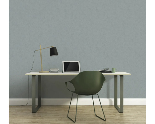 Arbeitszimmer mit Schreibtisch, Stuhl, Lampe und Laptop vor einer Tapete