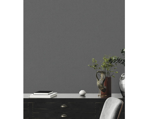 Detailansicht eines Wohnraums mit einer grauen Strukturtapete an der Wand, die eine elegante und moderne Atmosphäre schafft.