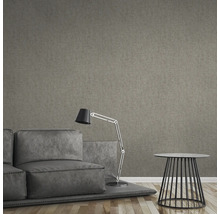 Wohnzimmer mit Sofa, Stehlampe, Beistelltisch und brauner Textiltapete