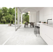 Espace de vie carrelé et lumineux avec coin repas et accès à la terrasse.