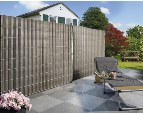 Garten mit Sichtschutzzaun, Liegestuhl und Haus im Hintergrund