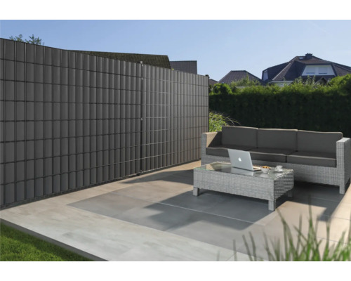 Gartenszene mit Sichtschutzzaun, Lounge-Möbeln und Terrasse