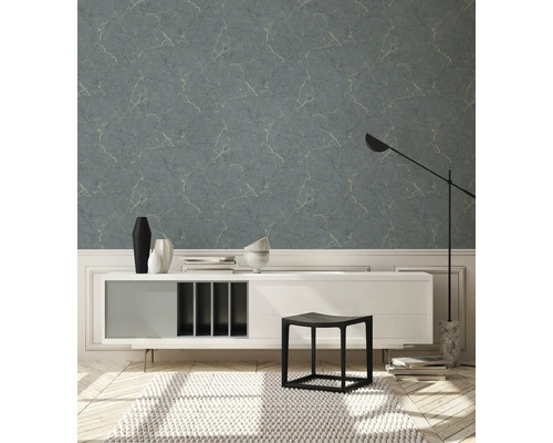 Salon avec papier peint bleu-gris aspect marbre, commode, tabouret et tapis