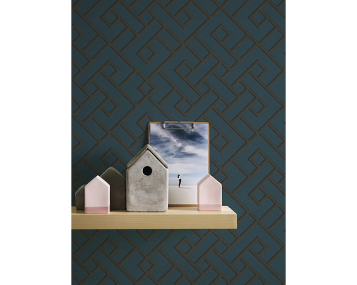 Motif géométrique décoratif sur papier peint, complété par une étroite étagère avec des objets de décoration.