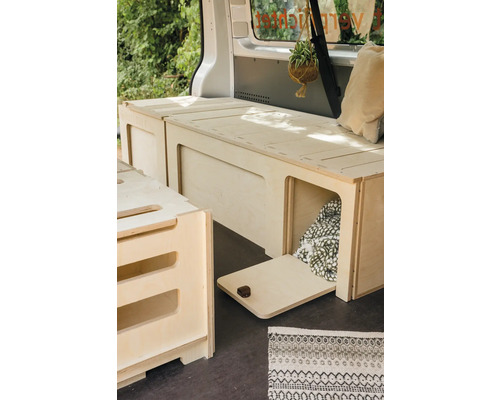 Innenausbau eines Lieferwagens mit Holzmöbeln, darunter Bett und Stauraum