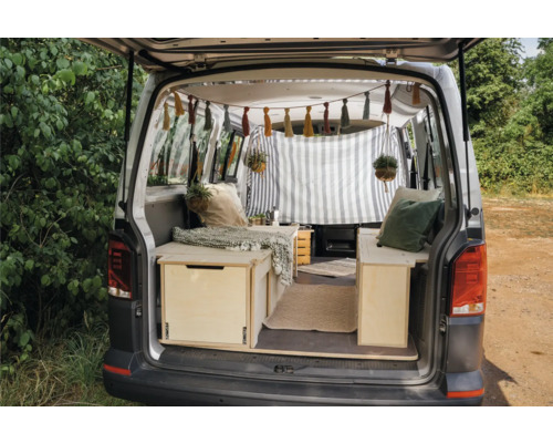 Innenraum eines ausgebauten Vans mit Holzmöbeln und dekorativen Elementen