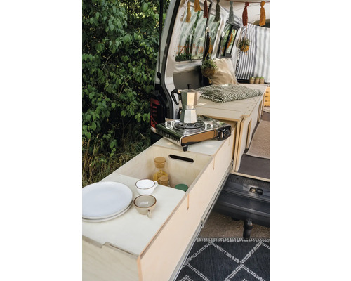 Campingausbau im Kofferraum mit Gaskocher, Geschirr und Lebensmitteln.