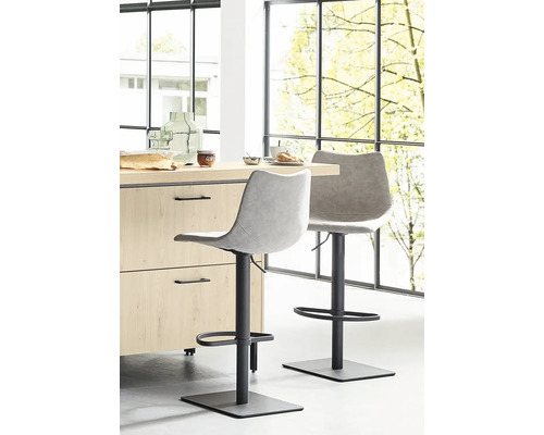 Deux tabourets de bar devant un comptoir de cuisine dans une pièce lumineuse.