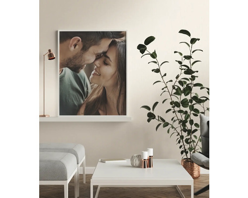 Wohnzimmer mit einem gerahmten Foto eines Paares, einem Couchtisch und einer Zimmerpflanze.