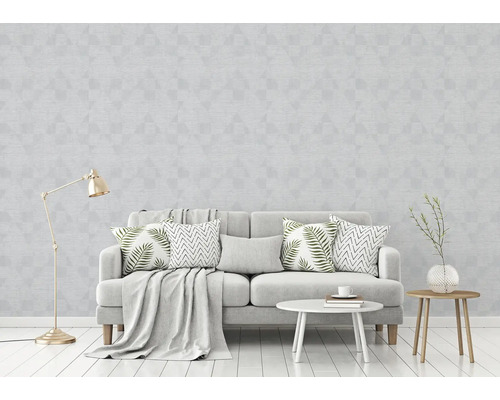 Wohnzimmer mit grauer Tapete mit geometrischem Muster, Sofa und Dekoration