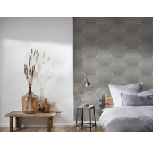 Schlafzimmer mit geometrischer Tapete, Holzhocker und Dekorationen