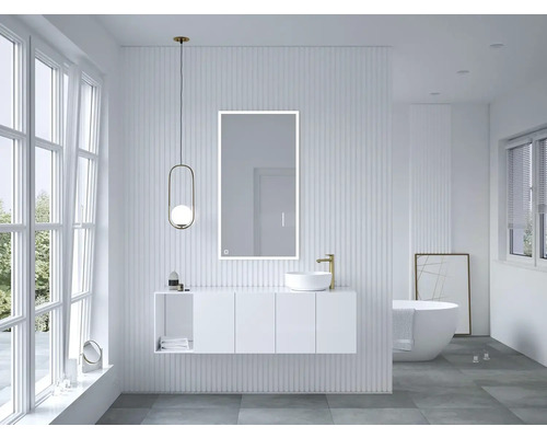 Salle de bains lumineuse avec lavabo, miroir, baignoire et fenêtre pour une ambiance moderne.